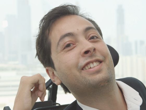Dr. Pineda in a wheelchair, smiling